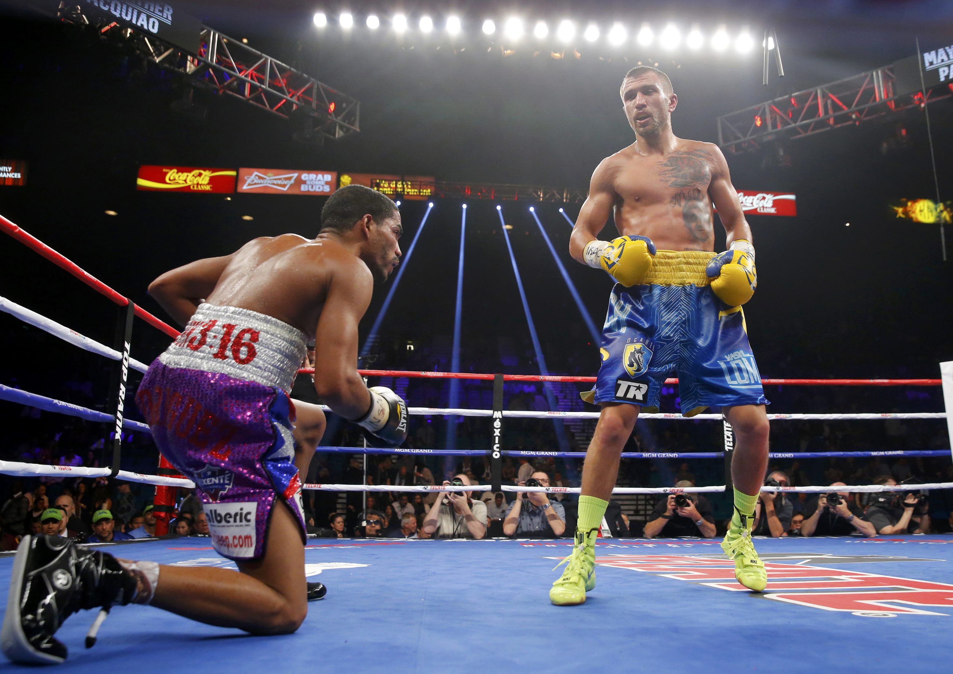Lomachenko of Ukraine looks on as Rodriguez of Puerto Rico goes down in the ninth round during their 12  round WBO featherweight title fight in Las Vegas